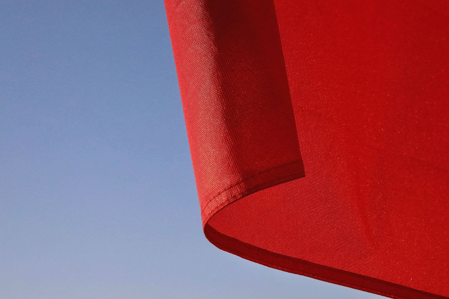Image of bottom corner of a red flag against a blue sky. Newsweek Red Flags for Toxic Relationships - Stephanie Sarkis - article -cristi-goia-cn6WRiJDA4E-unsplash.jpg