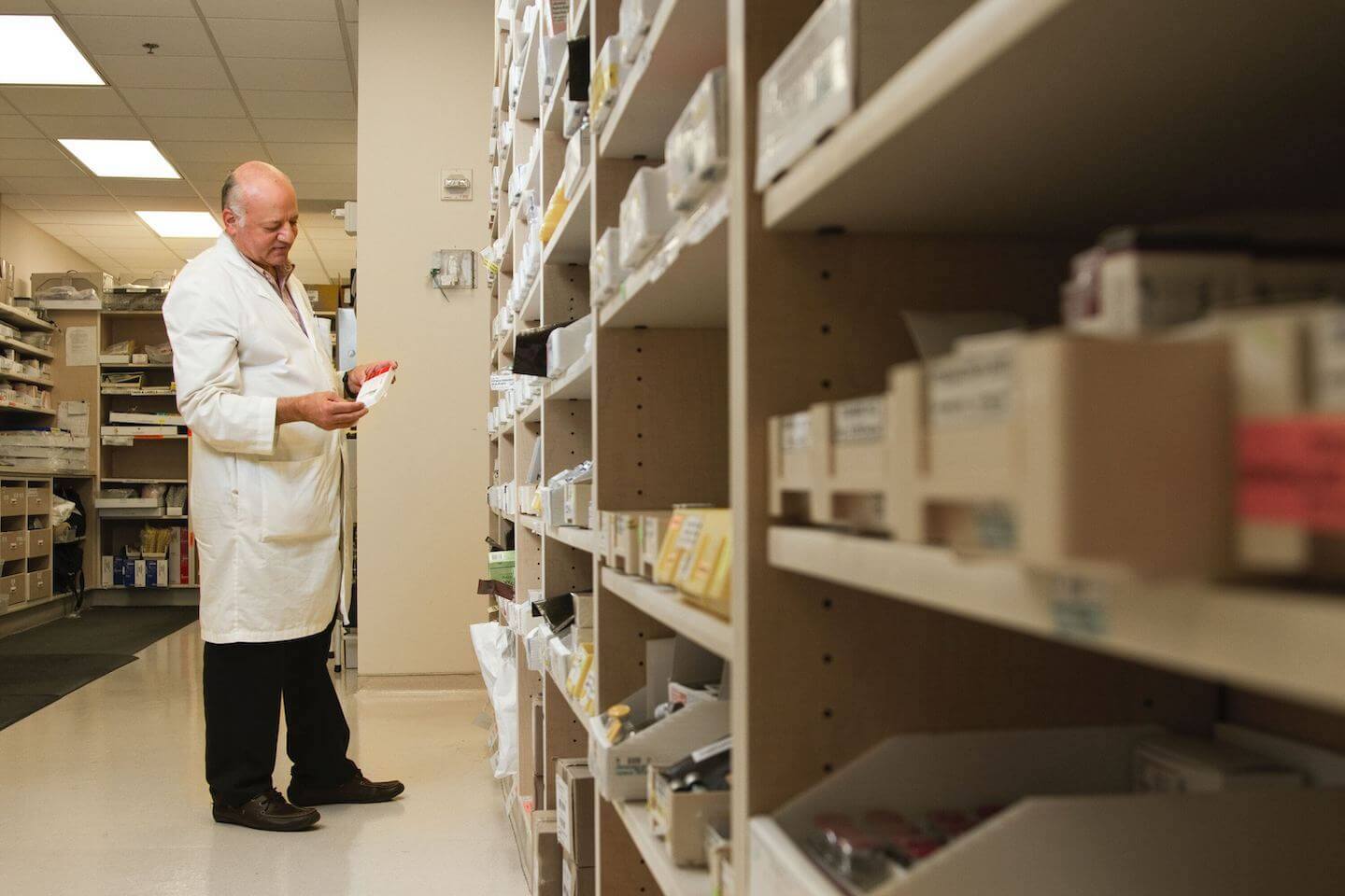 Photo of pharmacist facing medication shelves. Article info: ADHD and the Adderall Shortage on Psychology Today by: Dr Stephanie Sarkis. Photo Credit: national-cancer-institute-fTQHPb6r4wQ-unsplash.jpg
