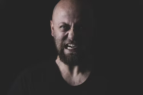 Photo of a bald man with a beard a furrowed brown and is gnashing his teeth. Post photo for "Why Toxic People are So Harmful" on Psychology Today by: Dr Stephanie Sarkis.
